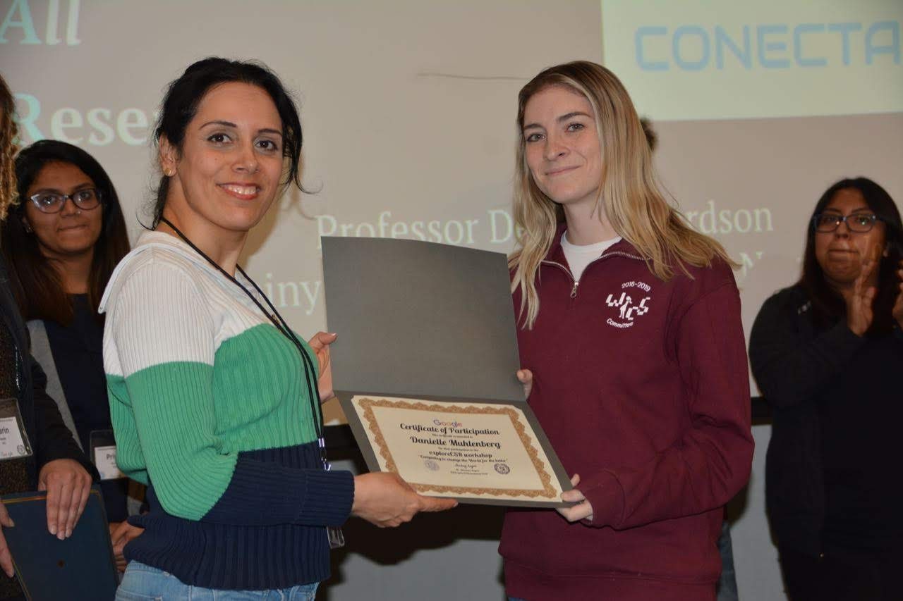 Receiving a certificate after presenting initial CONECTAR research questions at CSR event.